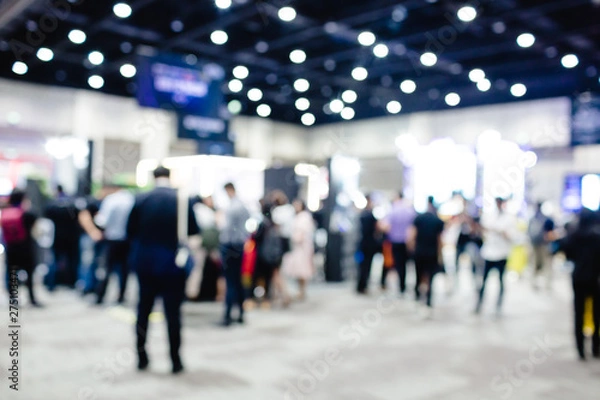 Fototapeta Blurred exhibition event in hall with many people on background. many businessmen are walking in the seminar