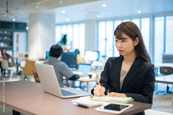 Fototapeta ワーキングスペースで仕事をする女性