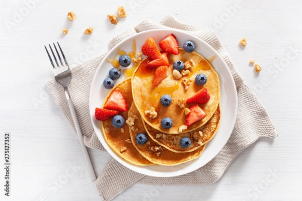 Fototapeta pancakes with blueberry strawberry honey and nuts for breakfast