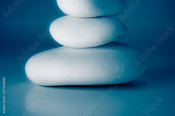 Obraz White stones stacked against a blue background - blurred and toned image