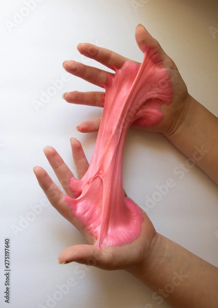 Fototapeta Hands Manipulating Pink Slime Hands pulling, twisting, squeezing slime. Slime resembles bubble gum. Gooey, stretchy, flexible, satisfying, tactile experience. Gross texture. Childhood fun. Innocent pl
