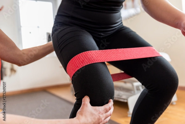 Obraz Physiotherapist doing with girl exercise for knee