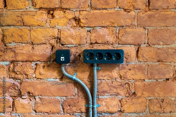 Fototapeta black socket on a red brick wall