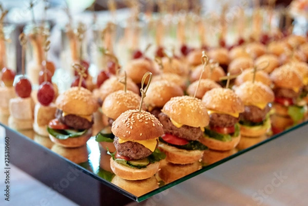 Obraz Buffet table with mini hamburgers and canape at luxury wedding reception, copy space. Serving food and appetizers at restaurant. Catering banquet table