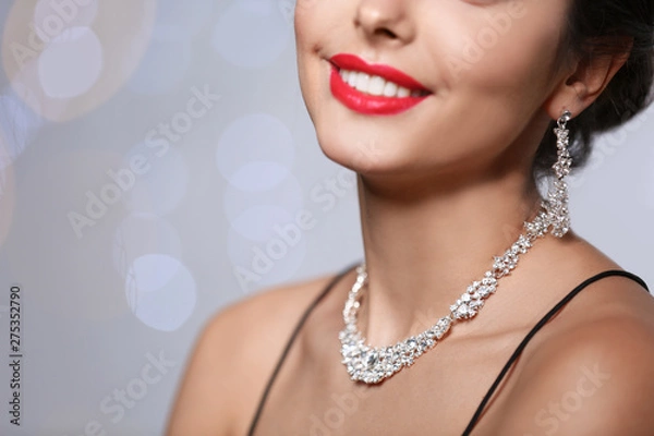 Obraz Beautiful woman with elegant jewelry on blurred background, closeup. Space for text