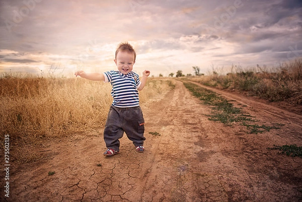 Fototapeta Baby's first steps in nature. The first independent steps.