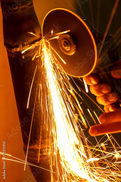 Obraz Man at work grinding iron pipe