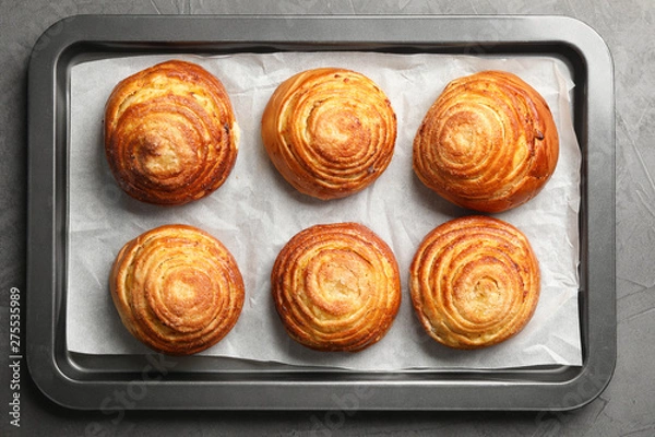 Fototapeta Baking sheet with buns on grey stone background, top view. Fresh from oven