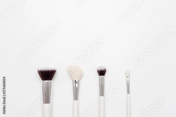 Fototapeta Set of makeup brushes, white background, copy space, advertising, slogan, text, top view