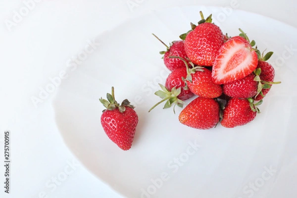 Fototapeta Close-up shot of fresh strawberries on a white plate. Isolated on white background.
