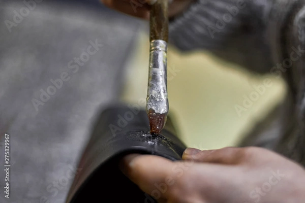 Fototapeta Tailor's hands is workin with glue and leather detail for bags .