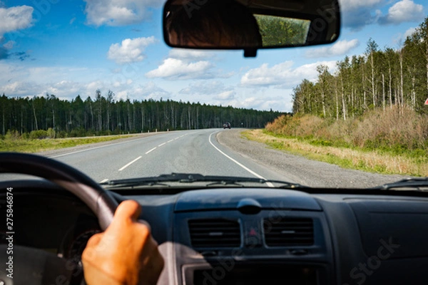 Fototapeta view of the road through the front window of the car