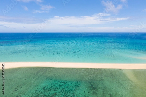 Fototapeta Sand beach island on a coral reef, top view. Atoll with an island of white sand.
