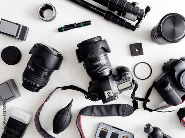 Fototapeta top view of work space photographer with digital camera, flash, cleaning kit, memory card, tripod and camera accessory on white table background