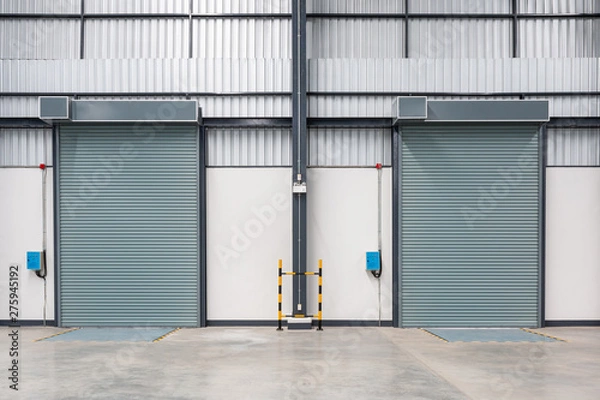 Obraz Roller shutter door and concrete floor inside factory.