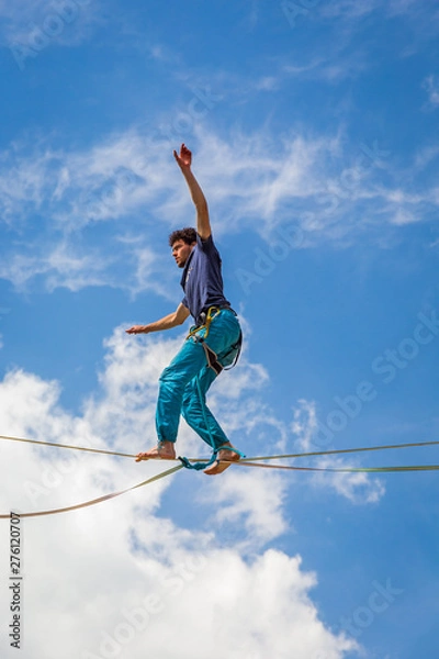 Obraz Young slackliner man balancing on a slackline betweend two rocks. Highline with a beautiful natural landscape behind