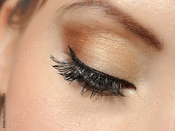 Fototapeta Beautiful macro shot of eye with long lashes and make-up in brow