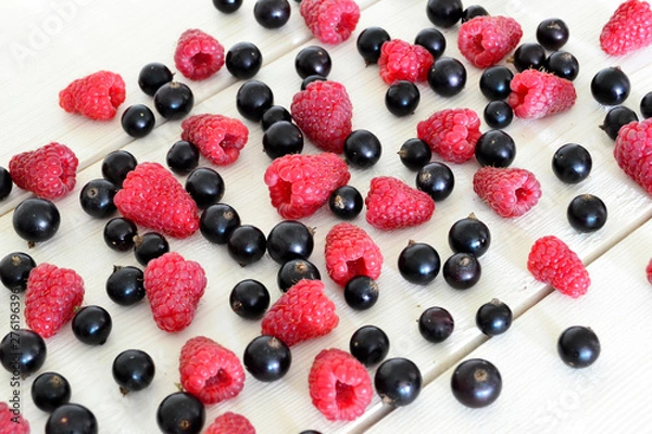 Obraz raspberry and black currant on wooden table