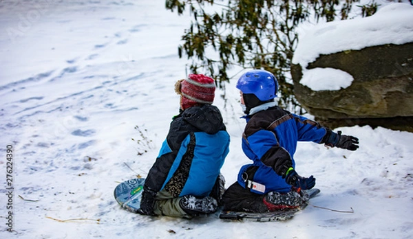 Fototapeta Kids sledding in the snow