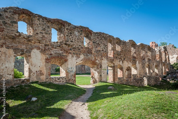 Fototapeta Ancient ruins of a knight's castle in Dobele. Overall view of the courtyard and surrounding area across  window openings in the wall. Dobele, Latvia.