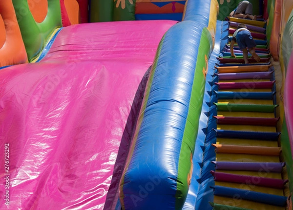 Fototapeta children play on an inflatable slide