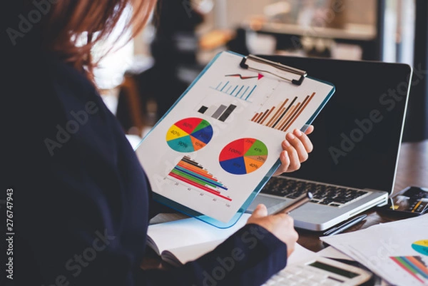 Fototapeta business person holding a file documents in the hand ,Businesswomen work in office using a laptop computer, job analysis and job description checking