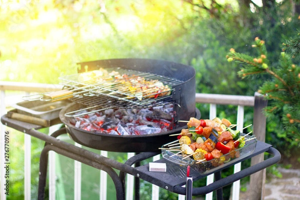 Obraz Assorted delicious grilled meat with vegetables over the coals on barbecue in green garden, summer party concept.