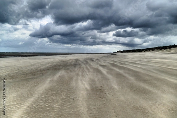 Fototapeta Impressive sand drifts and clouds during a hurricane at the Belgium coast
