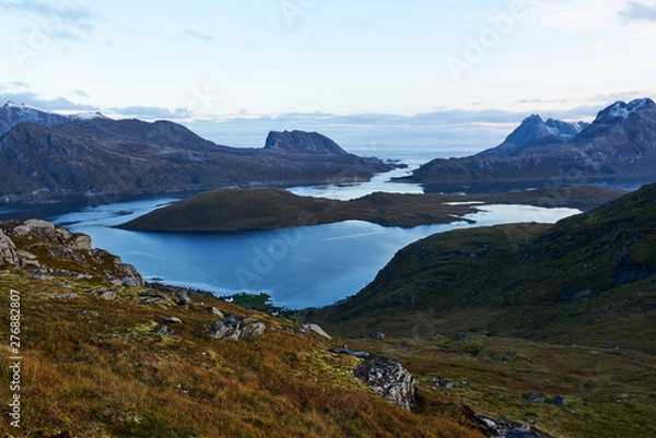 Obraz View from above over a bay with snowcapped mountains during evening blue hour on Lofoten Islands in Norway.