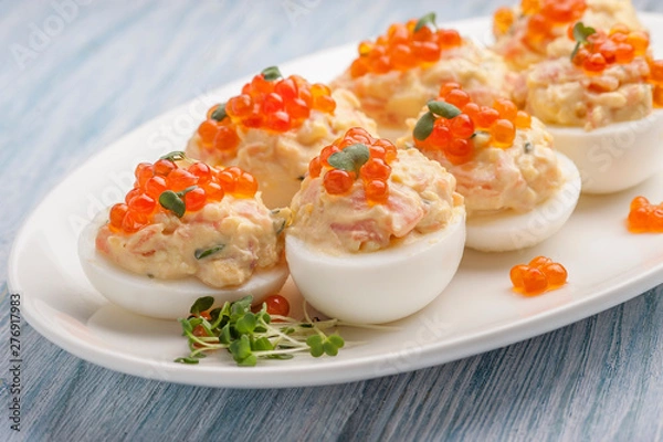 Obraz Stuffed eggs with red caviar.