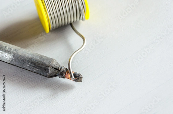 Obraz solder wire and soldering iron with wooden handle on gray background