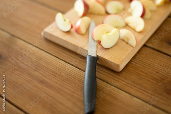 Fototapeta fruits, food cooking and eating concept - sliced apples and kitchen knife on wooden cutting board