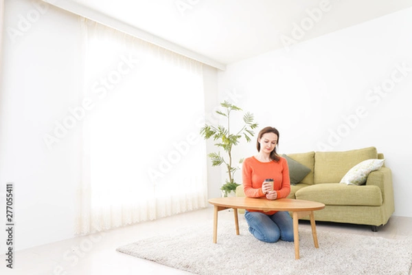 Fototapeta 家でコーヒーを飲む若い女性