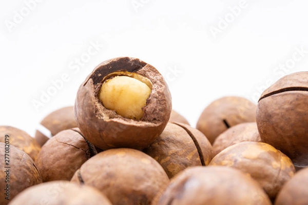 Fototapeta Fruits of the Australian macadamia nut on a white background. Kernels with a Shelled Shell