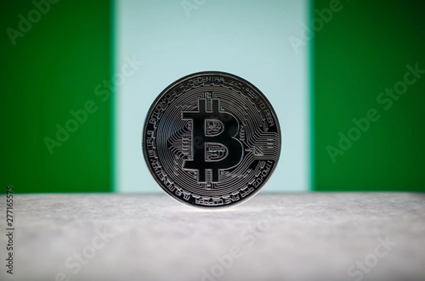 Fototapeta Physical silver version of Bitcoin (BTC) and Nigeria Flag on the background. Conceptual image for investors in cryptocurrency and Blockchain Technology.