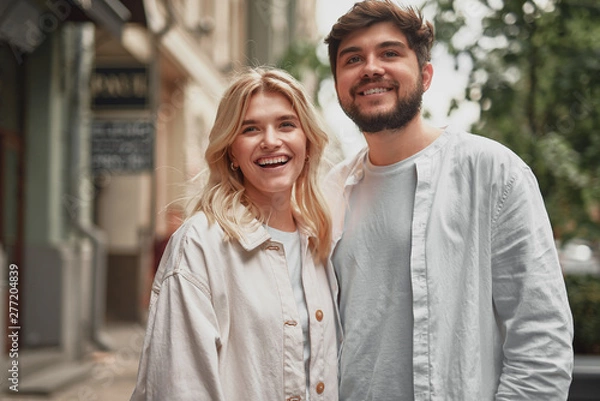 Fototapeta Happy couple standing near the building and smiling