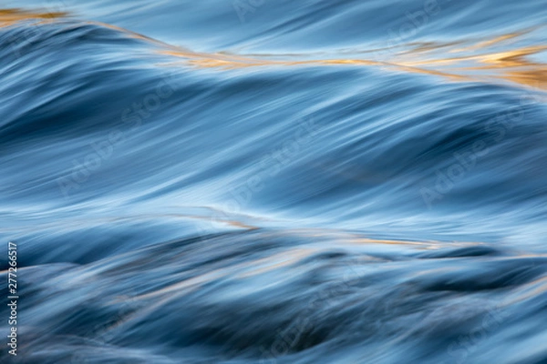 Fototapeta Water concept - river water flowing with light reflecting of its surface - long exposure shot