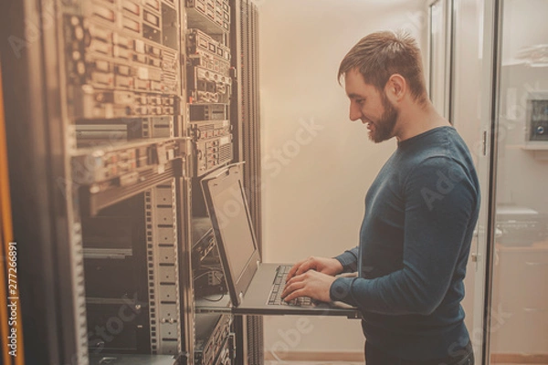 Obraz network engineer working in server room