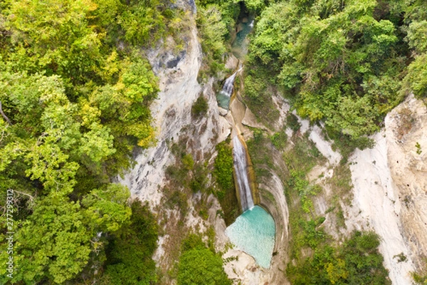 Fototapeta Waterfall in the rainforest jungle from above. Tropical Dao waterfalls in mountain jungle. Philippines, Cebu. Large waterfall in a mountain gorge.