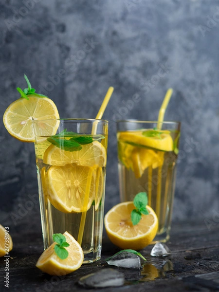 Fototapeta Summer refreshing lemonade with lemon and mint on a wooden table close-up