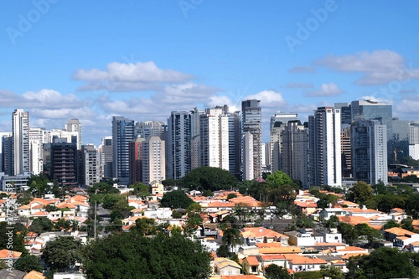 Fototapeta Flat cityscape with blue sky, white clouds and sun. Modern city skyline flat panoramic background. Urban city tower skyline illustration