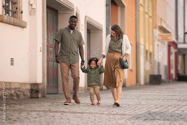 Obraz full length shot of parents with daughter holding hands and walking on the street