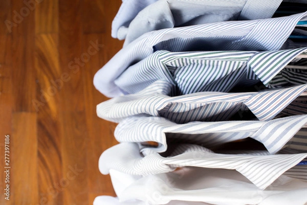 Fototapeta Men shirts hanging on rack in a row, Top view
