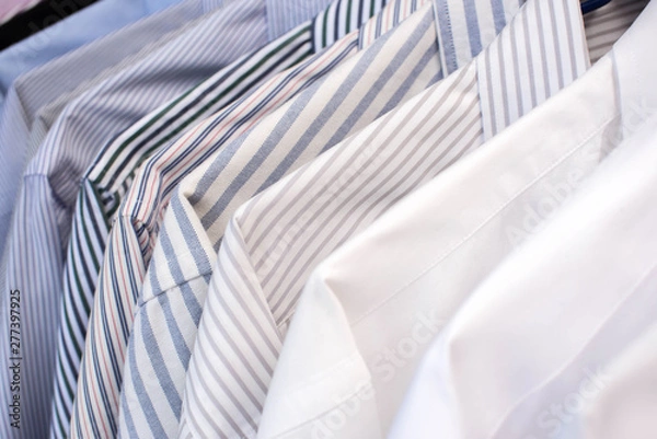 Fototapeta Men shirts hanging on rack in a row, Selective Focus