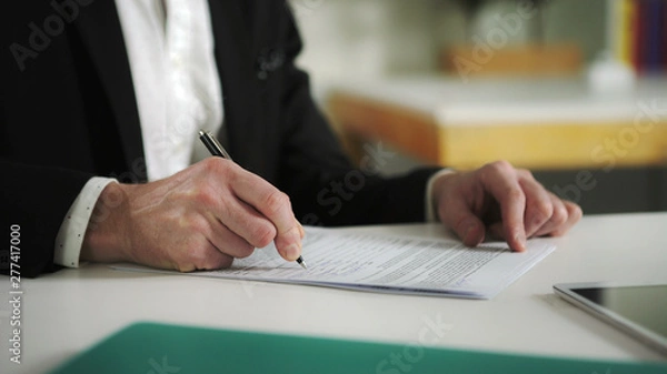 Obraz Man sign documents turning over the sheets. UHD