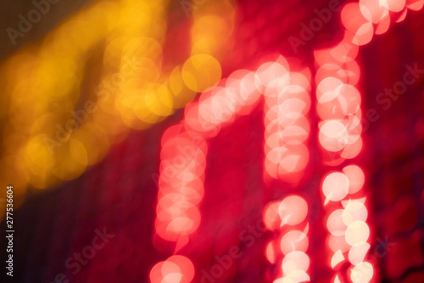 Fototapeta Out-of-focus effect, orange and red LED lights from the scoreboard. Suitable to be a background image.