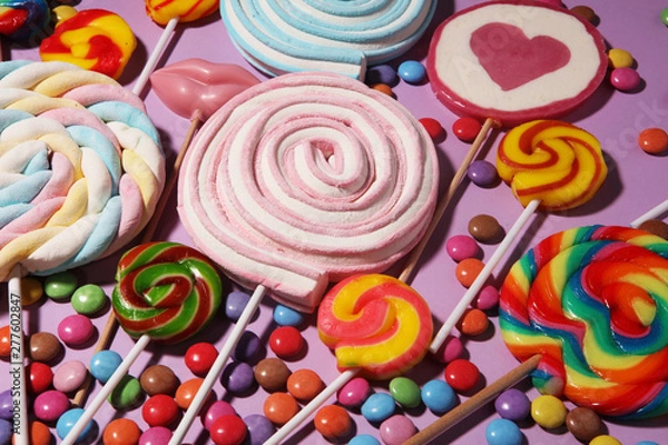 Fototapeta lollipop candies with jelly and sugar. colorful array of different childs sweets and treats on color background