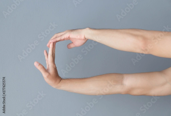 Fototapeta stretching exercises finger on grey background, health care and medical concept