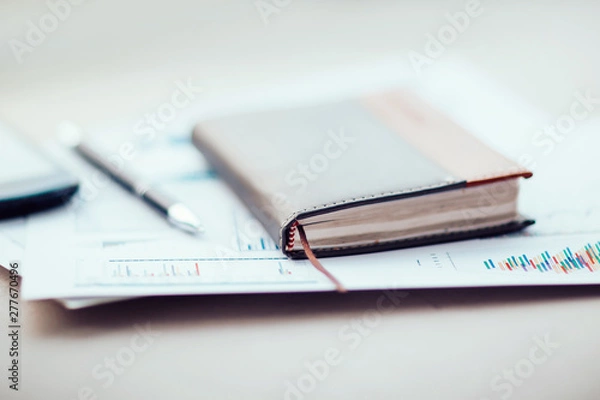 Fototapeta notebook and financial chart on the office Desk
