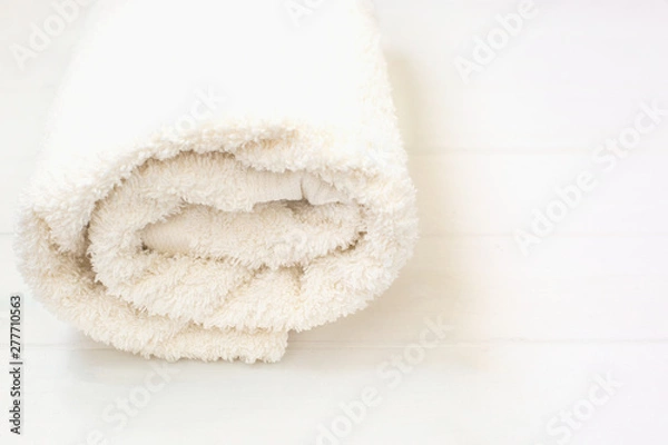 Fototapeta white terry towel rolled up on a white isolated background